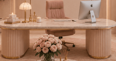 An oval coffee table featuring a light-colored marble top and two substantial, cylindrical pedestal bases. The bases are finished in a pale pink or peach hue with a distinct fluted texture, and each base is accented with a gold-tone band at its bottom edge. A thin gold-tone trim also outlines the edge of the tabletop, adding a touch of elegance to the modern design. — 3D model