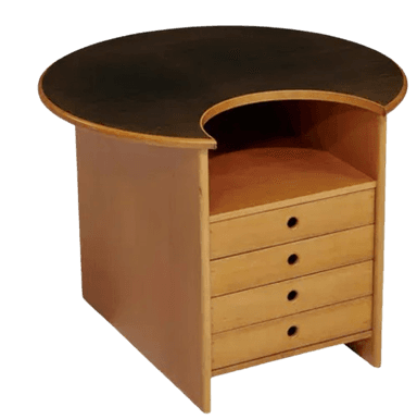 A chest of drawers with an asymmetric, kidney-shaped tabletop. The tabletop is darker than the rest of the unit and appears to have a wood grain finish. The main body of the chest is made of lighter wood and features four drawers stacked vertically. Each drawer has a single circular handle. Above the drawers is an open shelf space. The overall design is modern with organic curves. — 3D model