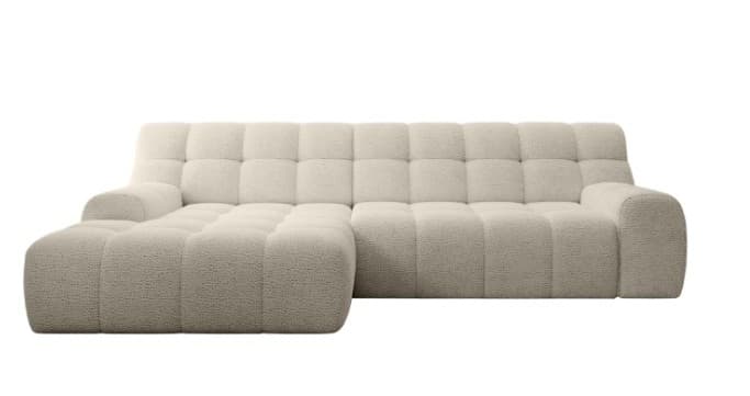 A modular sectional sofa with a chaise lounge extension. The sofa features a deep seat and back design with a tufted pattern composed of square indentations. The upholstery has a textured, bouclé-like finish. The armrests are integrated and have a rounded, soft profile. — 3D model