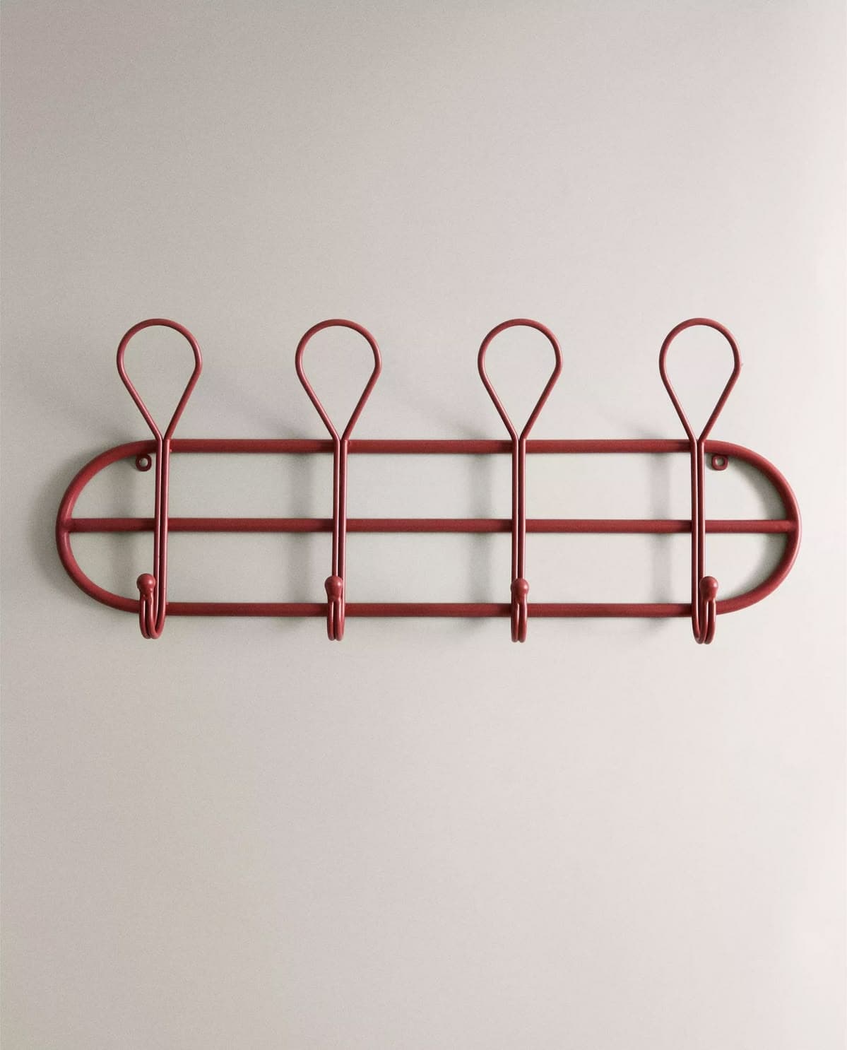 A wall-mounted coat rack featuring an oval frame with an internal horizontal bar supporting four hook elements. Each hook is formed by a vertical stem extending from the horizontal bar, topped with a teardrop-shaped loop. The entire structure is made of metal and is painted a matte red color. — 3D model