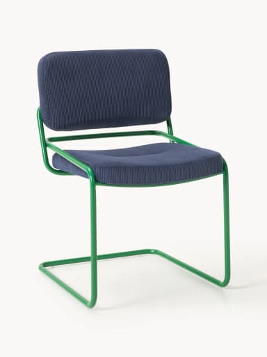 A side profile view of a modern accent chair. The chair features a tubular metal frame, painted in a vibrant green, forming cantilevered legs and armrests. The seat and backrest are upholstered in a navy blue corduroy fabric with a ribbed texture. The seat is slightly tufted. — 3D model