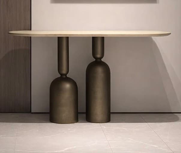 An elongated console table with a light, oblong top and two substantial, sculptural bases in an aged bronze finish. — 3D model