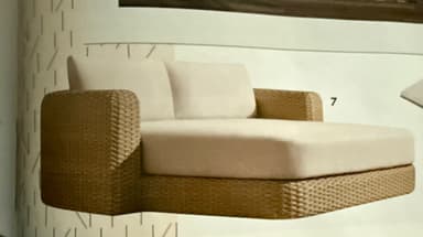 A modern outdoor chaise lounge featuring a woven wicker base and frame, with plush, light-colored fabric cushions for comfort. The chaise has a backrest with two individual cushions and a single armrest on the left side (when viewed from the front). The design is sleek and contemporary, suitable for outdoor living spaces. — 3D model