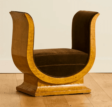 A distinctive bench with a U-shaped frame supporting a cushioned seat. The frame has a glossy, textured finish and appears to be made of wood or a composite material. The seat is upholstered in a dark brown velvet fabric. The overall design suggests a modern or art deco influence. — 3D model