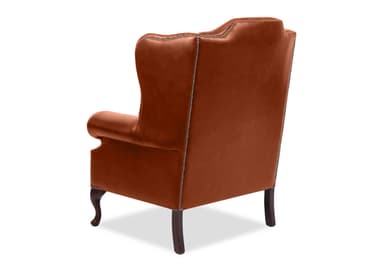 A classic wingback armchair upholstered in rich brown leather, featuring deep button tufting on its high backrest and rolled arms. The chair is accented with antique brass nailhead trim along the front of the arms and the side panels. It rests on four dark wood cabriole legs. — 3D model