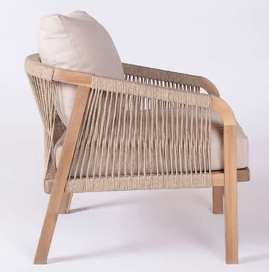 A contemporary lounge chair featuring a light-colored wooden frame with an open weave of natural-toned rope forming the back and sides. It is equipped with a plush, light beige fabric cushion for the backrest, suggesting comfort and a relaxed seating experience. The chair has a clean, minimalist aesthetic with visible structural elements. — 3D model