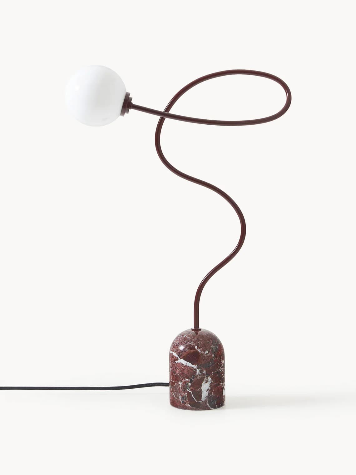 A contemporary table lamp with a distinctive design. It features a base made of red and white veined marble with a rounded, bell-like shape. A slender, dark red stem curves dramatically upwards and to the left, terminating in a white, globe-shaped light source. A black electrical cord is visible connected to the base. — 3D model