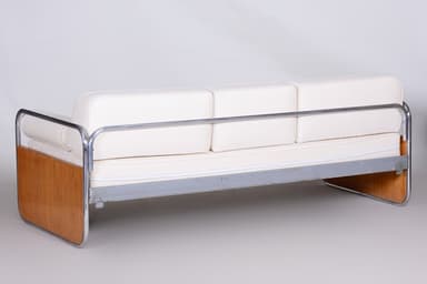 A three-seater sofa characterized by its tubular chrome frame, light wood end panels, and white upholstered cushions. The sofa features a minimalist design with a visible metal frame that extends to form the legs and back support. It includes three separate seat cushions, three back cushions, and two cylindrical bolster armrests at each end. The wood panels are integrated into the frame at the side ends. — 3D model
