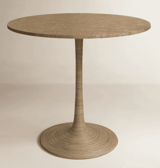 A round table featuring a natural travertine stone top with a subtly textured surface. The table is supported by a single, tapered pedestal base that exhibits a reeded or fluted texture, extending down to a matching circular plinth. The overall color palette is a warm, earthy beige or tan. — 3D model