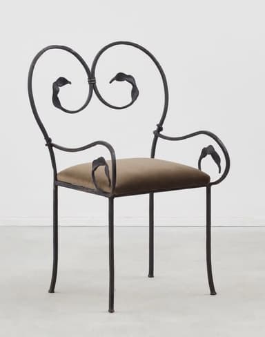 An ornate armchair featuring a dark, possibly wrought iron, frame with intricate scrollwork and leaf motifs on the backrest and armrests. It has a plush, olive green velvet upholstered seat cushion and four slender, slightly curved legs. — 3D model