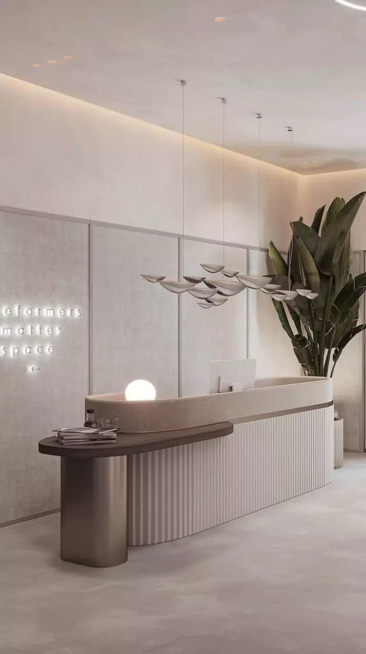 A modern reception desk with a curved, multi-tiered design. The main body features vertical fluting, with a smooth, rounded countertop and an integrated, minimalist spherical light fixture. A cylindrical support element is present on one end, and a planter with a lush green plant is integrated into the rear curve. — 3D model