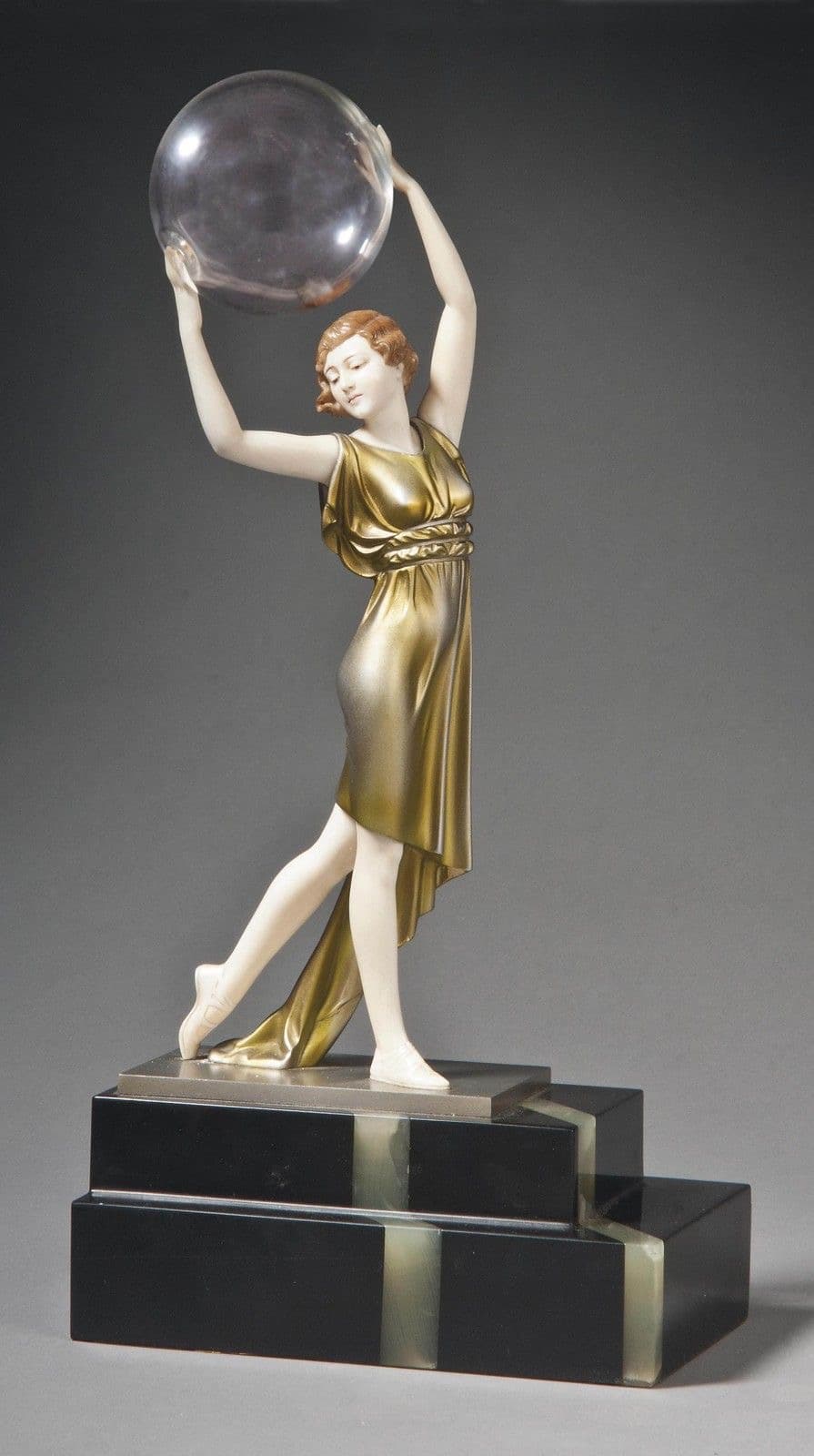 An Art Deco style sculpture featuring a female figure in a golden flowing dress, holding an opaque white sphere above her head. The figure is posed dynamically, standing on one leg with the other bent. The sculpture rests on a multi-tiered black and white geometric base, typical of the Art Deco aesthetic. — 3D model