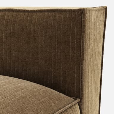 A modular sofa section with a low profile and plush cushioning. It features a single armrest or back support rising vertically from the seat, with a distinct seam line around the perimeter of the base and the seat cushion. The upholstery appears to be a textured fabric with a ribbed pattern. — 3D model