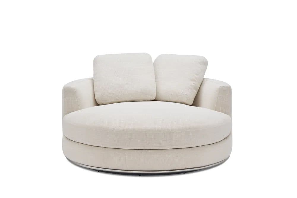 An off-white, plush, round lounge chair featuring a full swivel mechanism and two loose back cushions. The chair has a low-profile, circular upholstered base with a visible polished metal ring at the bottom, indicating its swivel function. The main seating area is a large, deep circle, designed for comfort and relaxation. The back is a continuous low-curved upholstered form, providing gentle support. — 3D model