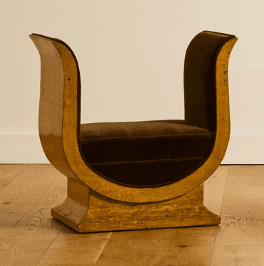 A distinctive bench with a U-shaped frame supporting a cushioned seat. The frame has a glossy, textured finish and appears to be made of wood or a composite material. The seat is upholstered in a dark brown velvet fabric. The overall design suggests a modern or art deco influence. — 3D model