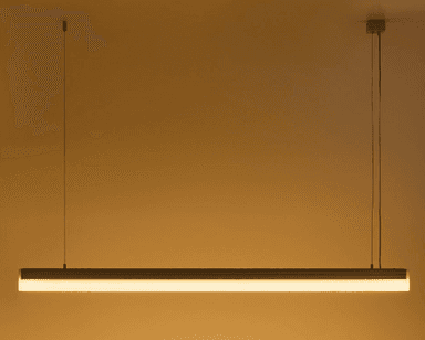 A modern, minimalist linear LED pendant light, suspended by two thin wires. It features a rectangular metallic housing, likely aluminum, with a translucent diffuser running along its length, indicating integrated LED illumination. — 3D model