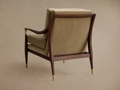 A plush armchair with a wooden frame and velvet upholstery. The armchair features a high back and seat cushions, with elegantly curved wooden arms. Decorative brass accents are present on the armrests and the tapered legs, which are capped with brass. — 3D model