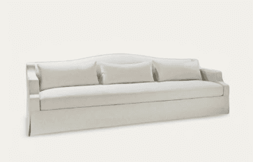 An off-white upholstered three-seater sofa featuring a skirted base, low track arms, and a subtly curved backrest, accompanied by three loose back cushions. — 3D model