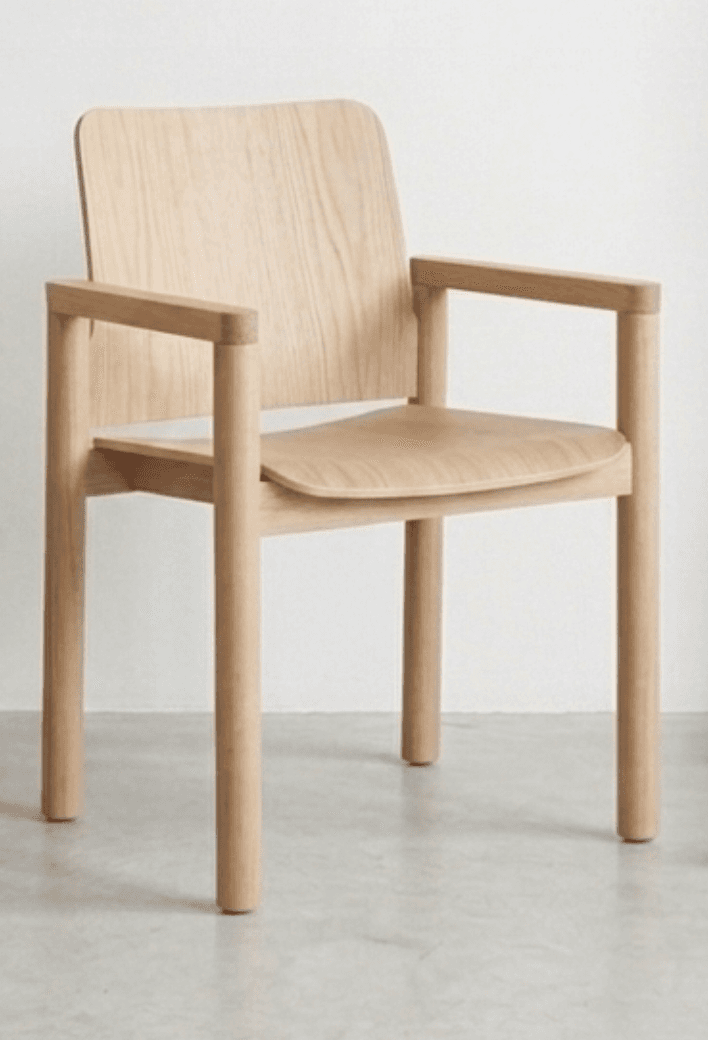 A modern armchair with a minimalist design. It features a curved wooden seat and backrest, supported by a frame of four cylindrical wooden legs and armrests. The construction appears to be primarily wood, with visible grain patterns. The overall aesthetic suggests a contemporary Scandinavian or mid-century modern influence. — 3D model