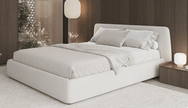 A modern, low-profile upholstered bed frame with a simple rectangular headboard and a matching base. The bed is dressed with light-colored bedding, including sheets, a duvet, and two standard pillows and one bolster pillow, all in neutral tones. — 3D model