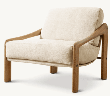 A contemporary lounge chair featuring a prominent, sculptural wooden frame with integrated armrests, supporting a deep-seated, upholstered cushion system. The frame is crafted from light-toned wood with a visible grain, possibly oak or ash, and has rounded edges. The seat and backrest are composed of thick, plush cushions upholstered in a cream or off-white bouclé fabric, providing a soft, textured contrast to the smooth wood. The design emphasizes comfort and a minimalist yet inviting aesthetic. — 3D model