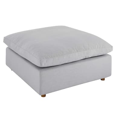A modern, square-shaped ottoman featuring a light gray, linen-look fabric upholstery. It consists of a plush, oversized top cushion resting on a slightly smaller, more rigid base, supported by small, subtly splayed wooden feet. — 3D model