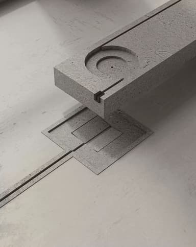 A minimalist, modular architectural fixture composed of a gray, coarse-textured material resembling concrete. The primary element is a thick, rectangular block featuring a deep circular depression with concentric rings, suggesting a basin and drain. This block is precisely fitted into a larger, flatter rectangular base that also exhibits stepped, recessed details and linear channels extending outwards. A long, narrow channel further extends from the main base, emphasizing a linear drainage design. The overall design is stark, geometric, and functional, rendered against a plain white background. — 3D model