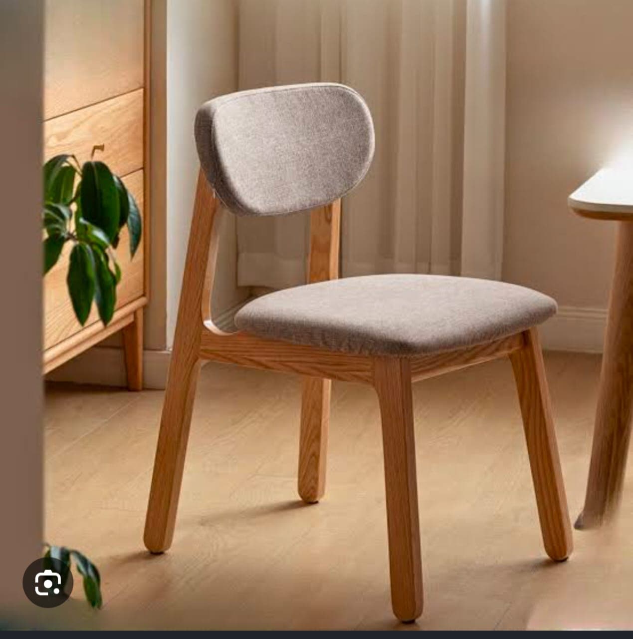 A modern armless dining chair featuring a light-toned wooden frame and upholstered seat and back in a neutral fabric. — 3D model