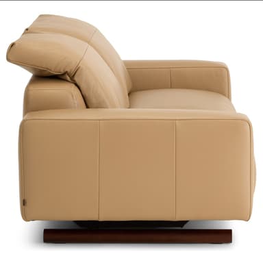 A modern two-seater reclining sofa, upholstered in smooth, light tan leather. It features two individual seats, each with a plush back cushion and integrated armrests. The sofa stands on small, dark-colored cylindrical feet, offering a minimalist profile. — 3D model