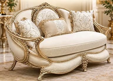 An ornate loveseat featuring a heavily carved and gilded wooden frame with a cream-colored upholstered seat and back. The frame exhibits intricate Rococo-style detailing, including scrolled motifs, acanthus leaves, and shell-like accents. It stands on four cabriole legs. The loveseat is adorned with multiple throw pillows in coordinating cream and patterned fabrics, finished with tassels, enhancing its luxurious appearance. — 3D model