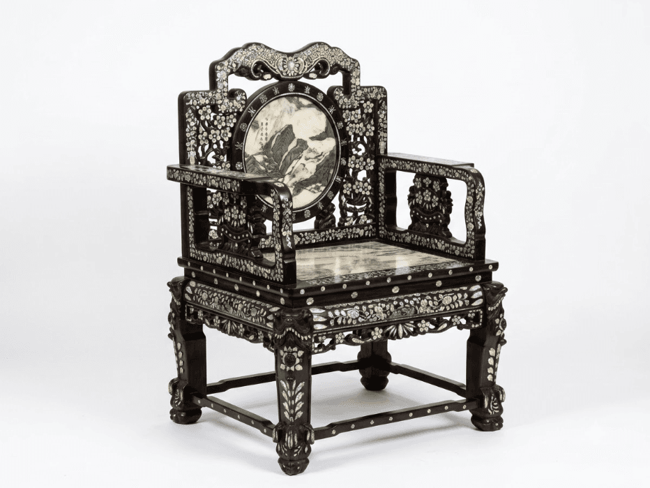 An antique East Asian armchair featuring a dark, carved hardwood frame extensively inlaid with iridescent mother-of-pearl. The chair has a square, polished marble seat with green and white veining. The backrest is ornate, topped with a shaped crest rail and a central circular panel depicting a landscape scene. The armrests and legs are also heavily decorated with floral and geometric mother-of-pearl inlay and intricate carving. — 3D model