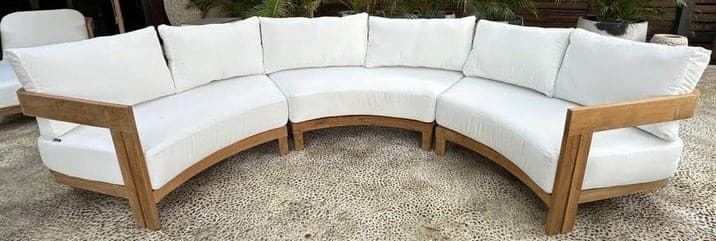 A modular outdoor sectional sofa with a curved design, featuring a wooden frame and white upholstered cushions and backrests. The sofa is composed of multiple curved sections connected to form a semi-circular arrangement. — 3D model