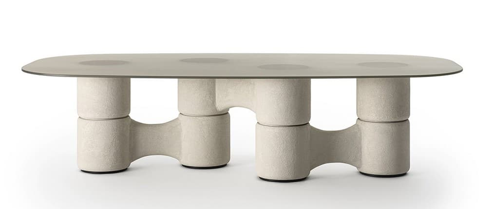 An oval-shaped coffee table with a smooth, matte finish glass top and a unique, sculptural base. The base consists of stacked cylindrical forms with interconnected, organic-shaped supports that give it a substantial yet visually light appearance. The material of the base appears to be textured, possibly a composite or concrete-like material, in a neutral beige tone. The tabletop is transparent or translucent with circular darker accents, possibly integrated design elements or reflections. The overall aesthetic suggests a modern or contemporary design. — 3D model