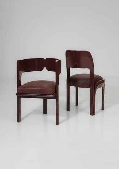 A striking postmodern armchair featuring a continuous, curved armrest and backrest in a high-gloss dark brown lacquered wood, complemented by a padded square seat upholstered in deep brown leather. — 3D model