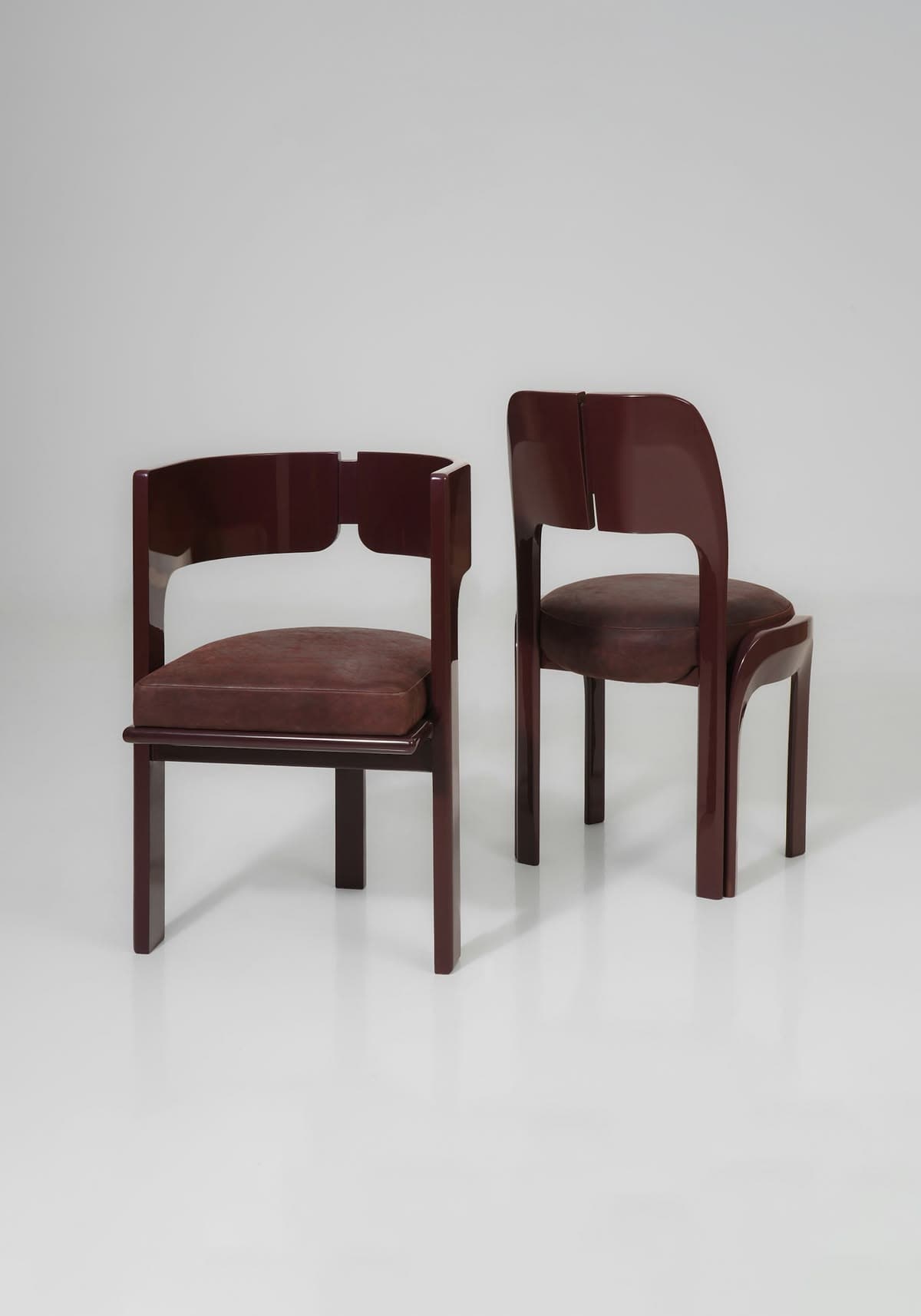 A striking postmodern armchair featuring a continuous, curved armrest and backrest in a high-gloss dark brown lacquered wood, complemented by a padded square seat upholstered in deep brown leather. — 3D model