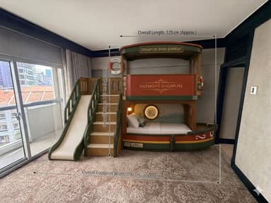 A highly detailed children's bunk bed system designed as a double-decker riverboat or ferry. The structure features a lower sleeping berth and an upper berth, accessed via a set of integrated stairs on the left side. A slide descends from the upper level alongside the stairs, providing an additional play element. The boat design includes a green roof, red and green hull accents, circular porthole windows, decorative life preservers, and signage, enhancing its whimsical, nautical theme. — 3D model