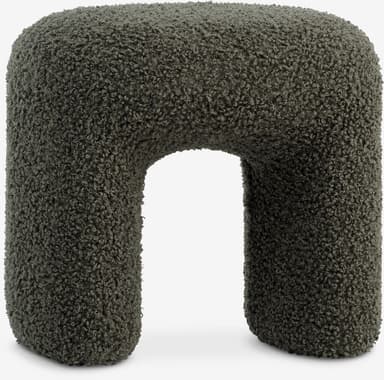 A contemporary U-shaped stool upholstered entirely in a dark green, textured boucle fabric. The design features soft, rounded edges and a monolithic form, creating a sculptural and inviting appearance. — 3D model