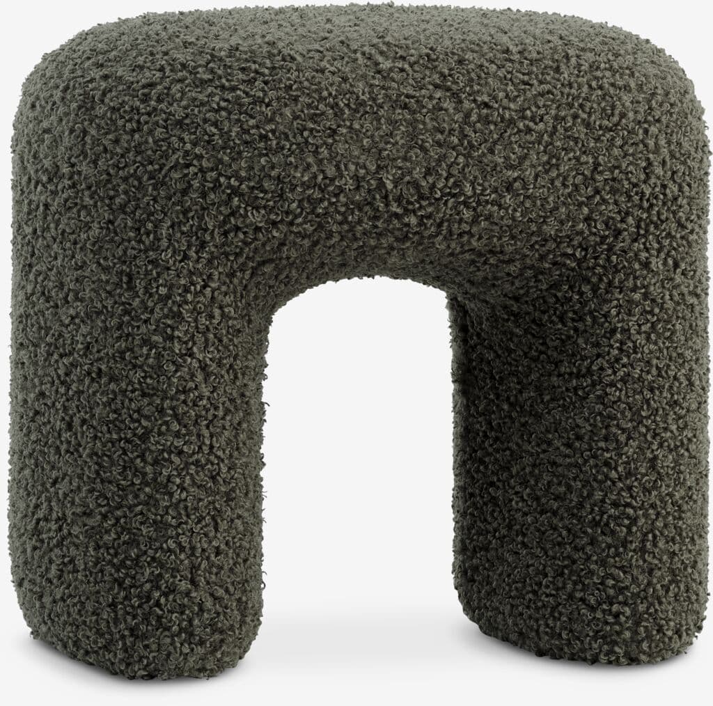A contemporary U-shaped stool upholstered entirely in a dark green, textured boucle fabric. The design features soft, rounded edges and a monolithic form, creating a sculptural and inviting appearance. — 3D model