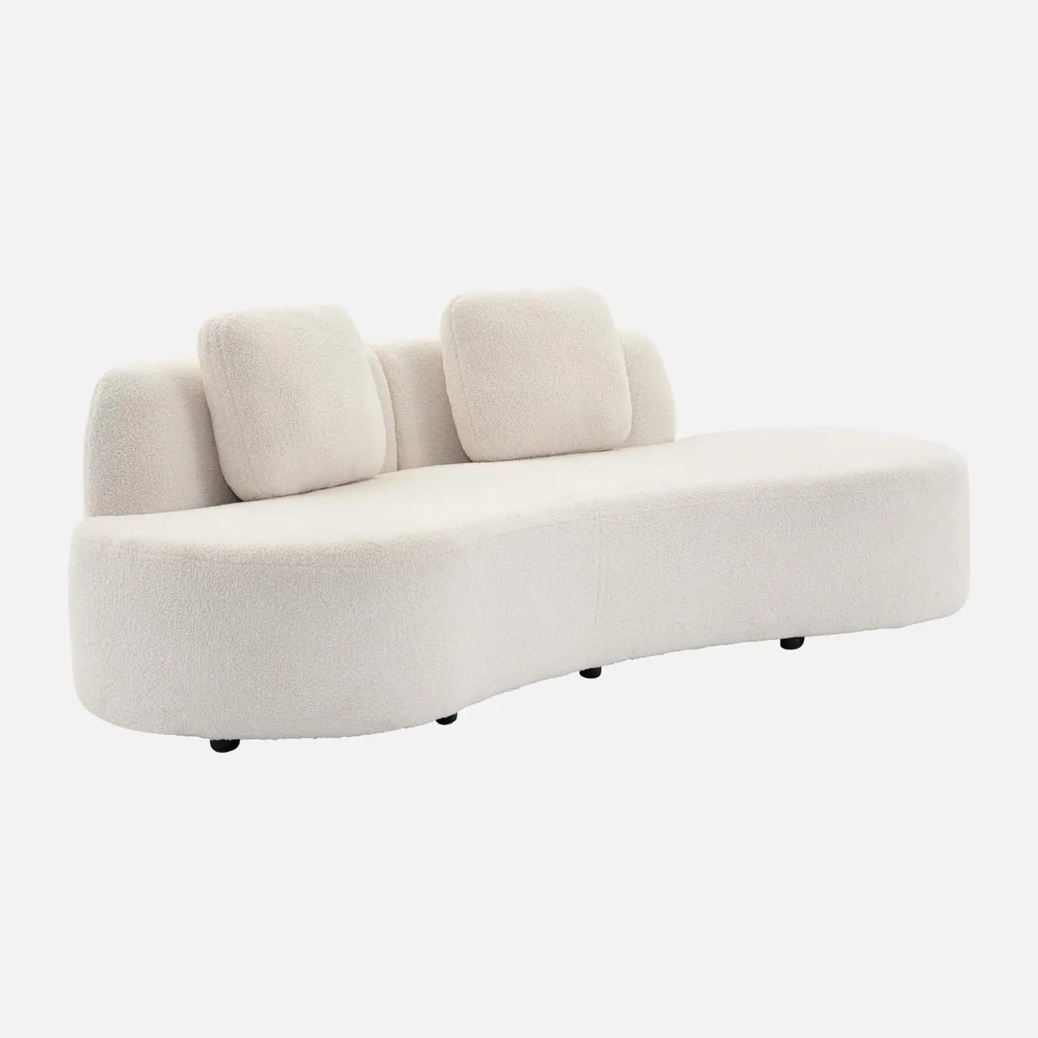 A modern, curved sofa with a plush, textured upholstery. It features a rounded chaise lounge-like design with a low profile and integrated back support. Two square throw pillows with matching upholstery are placed on the sofa. The sofa rests on small, dark, cylindrical feet. — 3D model