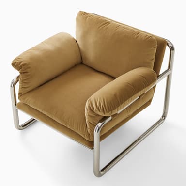 A modern armchair with a tubular chrome frame and plush, upholstered cushions in a camel or mustard yellow hue. The armchair features a low profile and a minimalist design, with the cushions appearing overstuffed and soft. The frame has a distinct cantilevered appearance. — 3D model