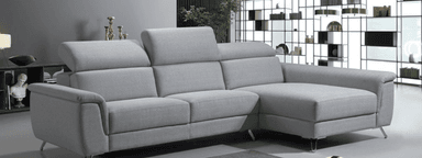 A modern sectional sofa with a chaise lounge extension. The sofa features multiple seat cushions, adjustable headrests, and is upholstered in a light gray fabric. It is supported by slender, angled legs. — 3D model