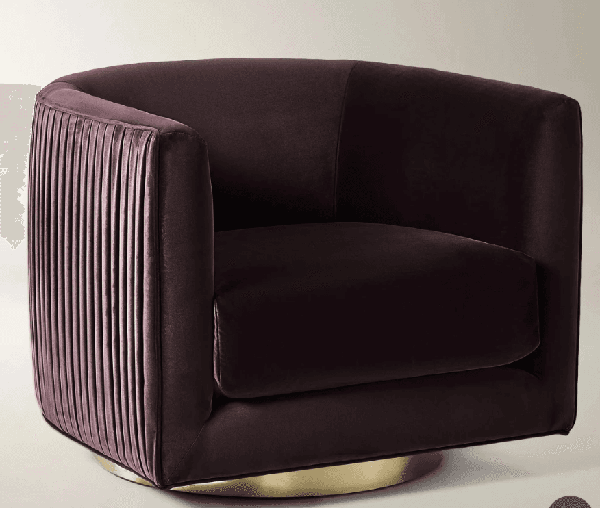 An upholstered barrel-style armchair featuring deep plum velvet fabric. One side of the chair back is adorned with vertical pleating, while the other side and interior remain smooth. The chair is supported by a circular, recessed brass swivel base. — 3D model
