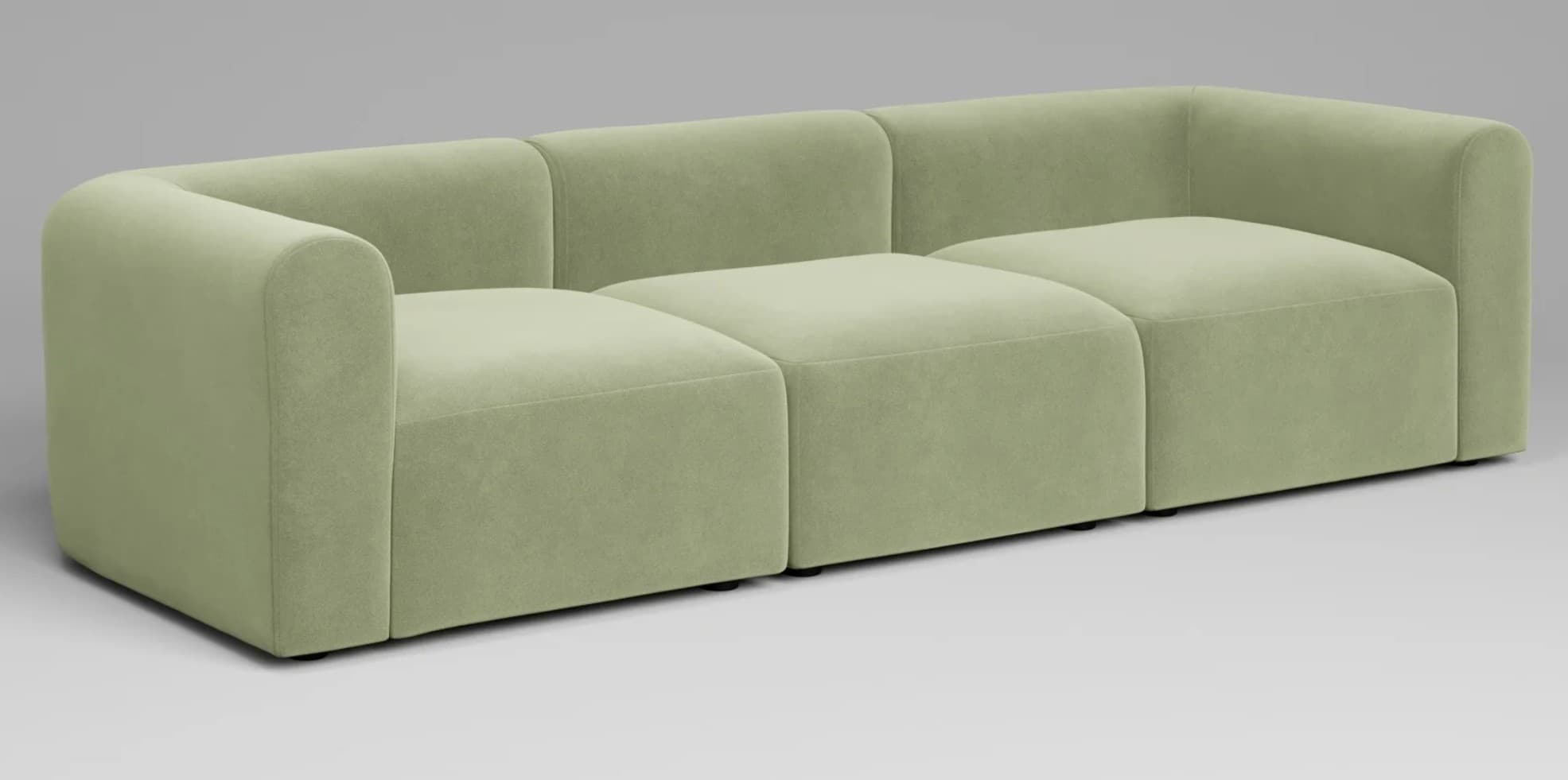 A contemporary three-seater modular sofa upholstered in a light green fabric. The design features a blocky silhouette with rounded track arms that flow into a low, integrated backrest. The sofa is composed of three distinct modular sections. — 3D model