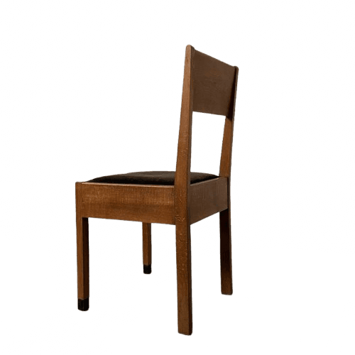 A side chair constructed primarily from medium-toned solid wood, featuring a rectangular upholstered seat in dark brown. The backrest is composed of a solid wooden frame with an open central space. The chair stands on four straight, square-profile legs, two of which extend upwards to form the backrest structure. The feet have small, black protective caps. — 3D model