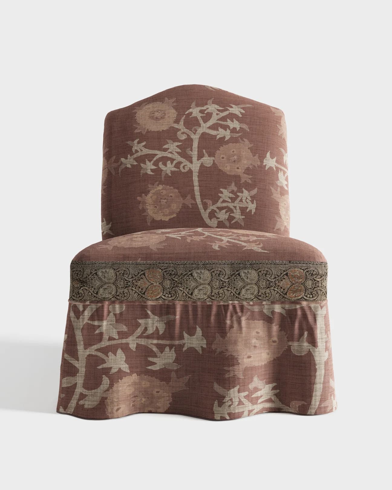 A fully upholstered, armless chair with a gently curved backrest and a pleated skirt. It features a patterned fabric with floral and botanical motifs, and a distinct decorative trim around the seat. — 3D model