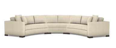 A contemporary, generously sized curved sectional sofa, upholstered in a light-colored, possibly off-white or beige, textured fabric. The sofa features a sweeping, semicircular form with wide, flat arms and five distinct seating sections. Each section has a loose seat cushion and a loose back cushion, accompanied by additional throw pillows at the ends. The sofa rests on dark, low-profile block feet, contributing to a clean, modern aesthetic. — 3D model