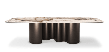 A contemporary dining table featuring a rounded rectangular tabletop with a stone-like pattern and a distinctive base. The base consists of multiple cylindrical columns with a wavy profile, finished in a dark metallic hue. — 3D model