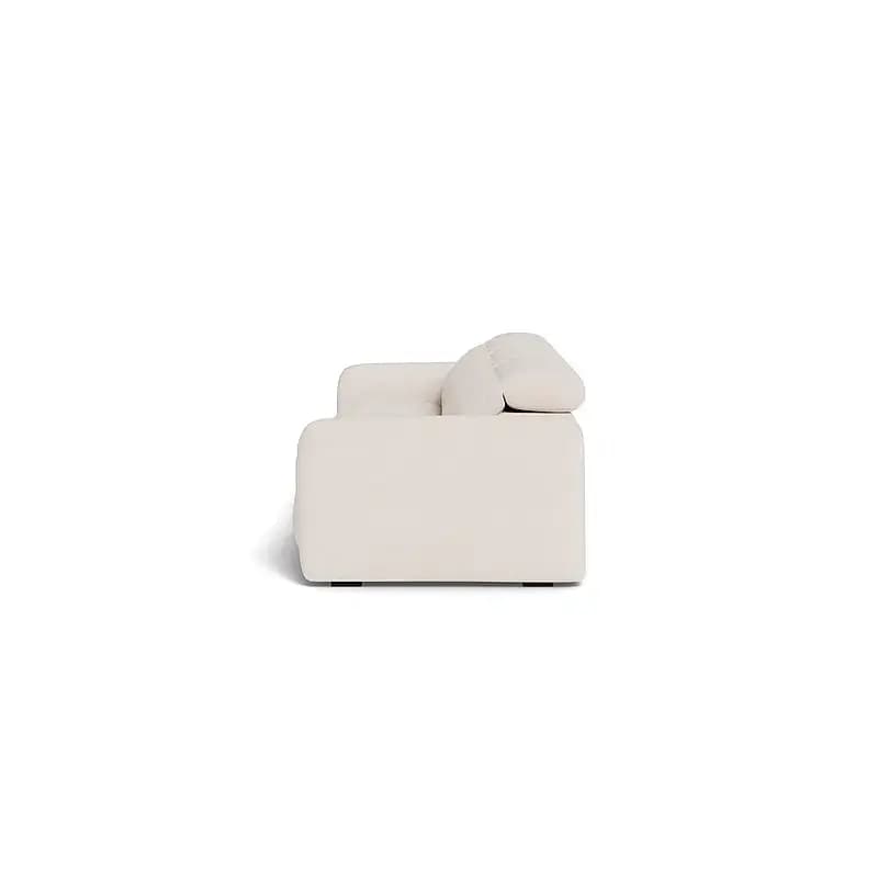 A single, deeply cushioned armchair, upholstered in a light-colored fabric, presented against a white background. The chair features a low-profile design with generous padding on the seat, backrest, and armrest, emphasizing comfort and a contemporary aesthetic. — 3D model