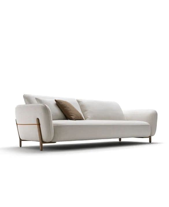A contemporary three-seater sofa upholstered in a light-colored fabric, featuring distinctive wooden and metallic side panel details on its armrests. The sofa includes two loose seat cushions, three loose back cushions, and three throw pillows (two white, one brown). It is supported by four small, dark wooden cylindrical legs. — 3D model