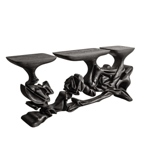 A highly sculptural console table featuring a dark, almost black, wood finish. It comprises three distinct, irregularly shaped flat display surfaces supported by an intricate, organically formed base that evokes draped fabric or fluid natural structures. The wood grain is visible through the dark finish, adding texture to its complex form. — 3D model